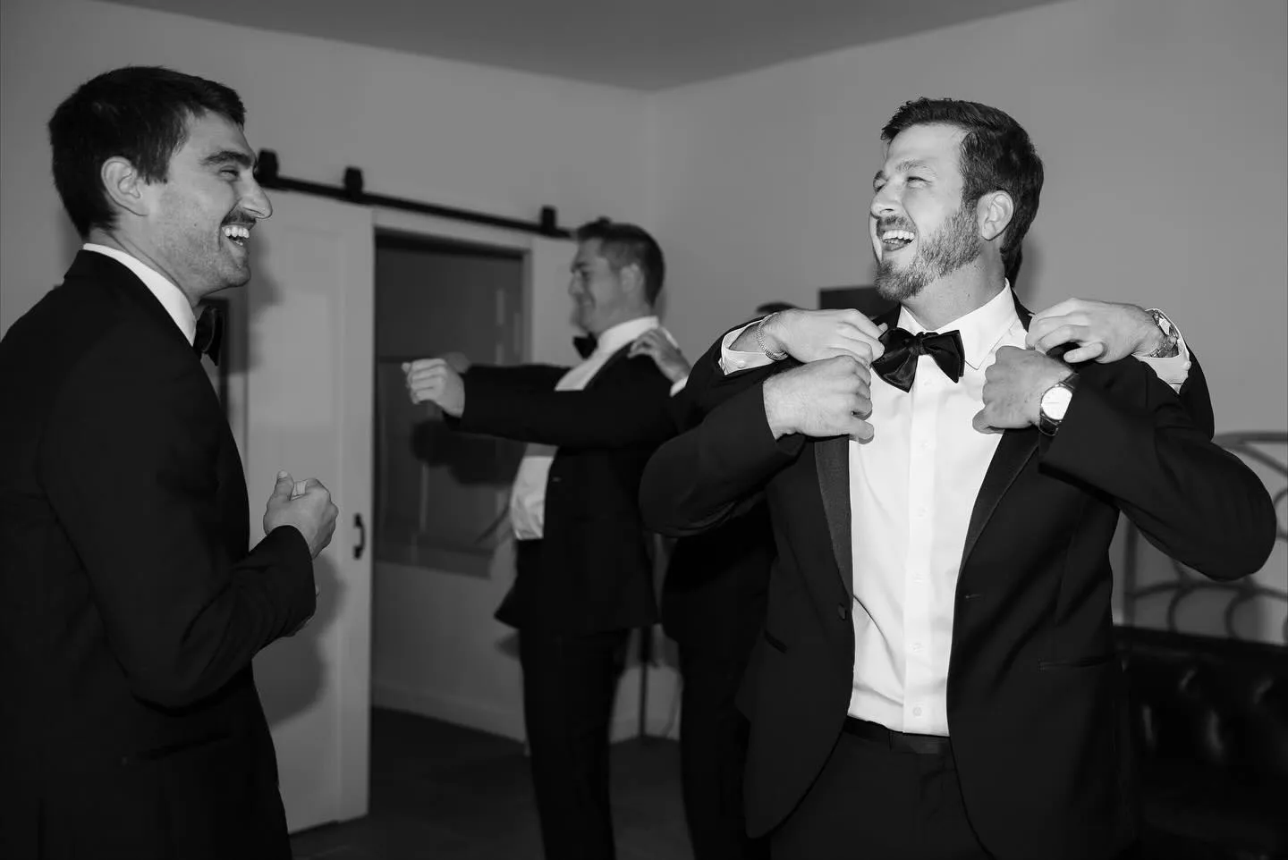 Black and white photo of groomsmen laughing together