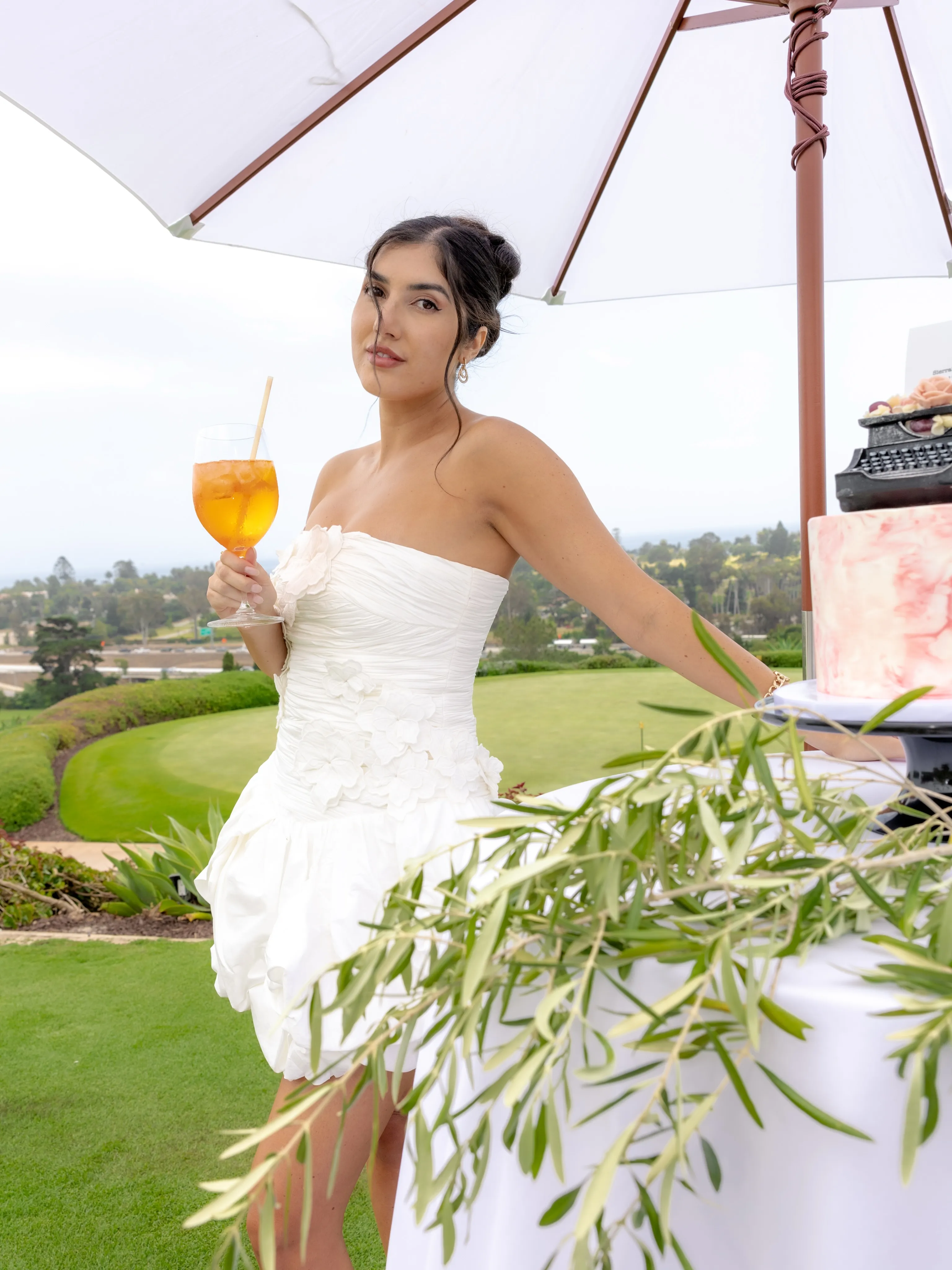 Guest with a spritz under a garden umbrella