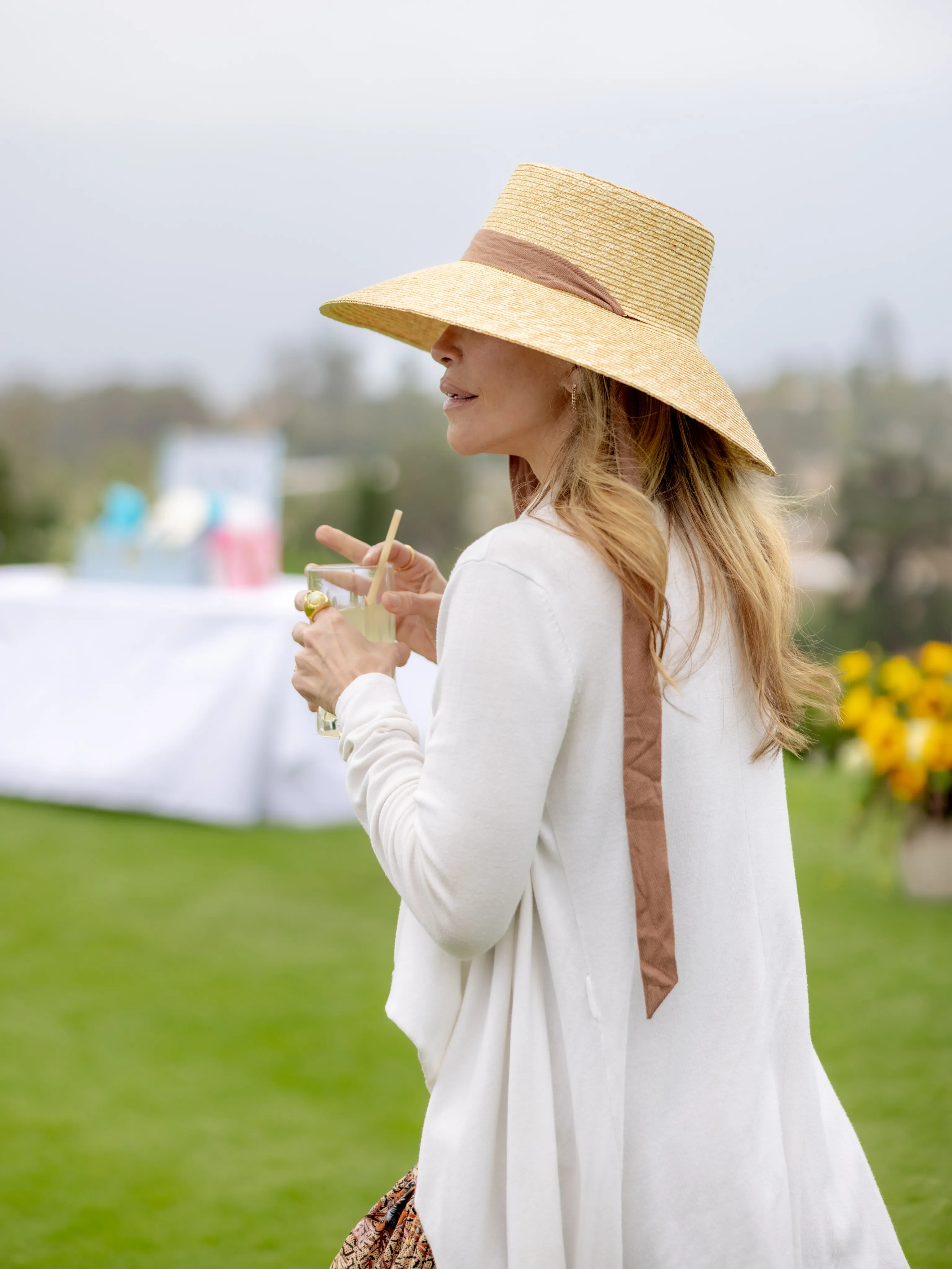 Guest in a wide straw hat at an outdoor party